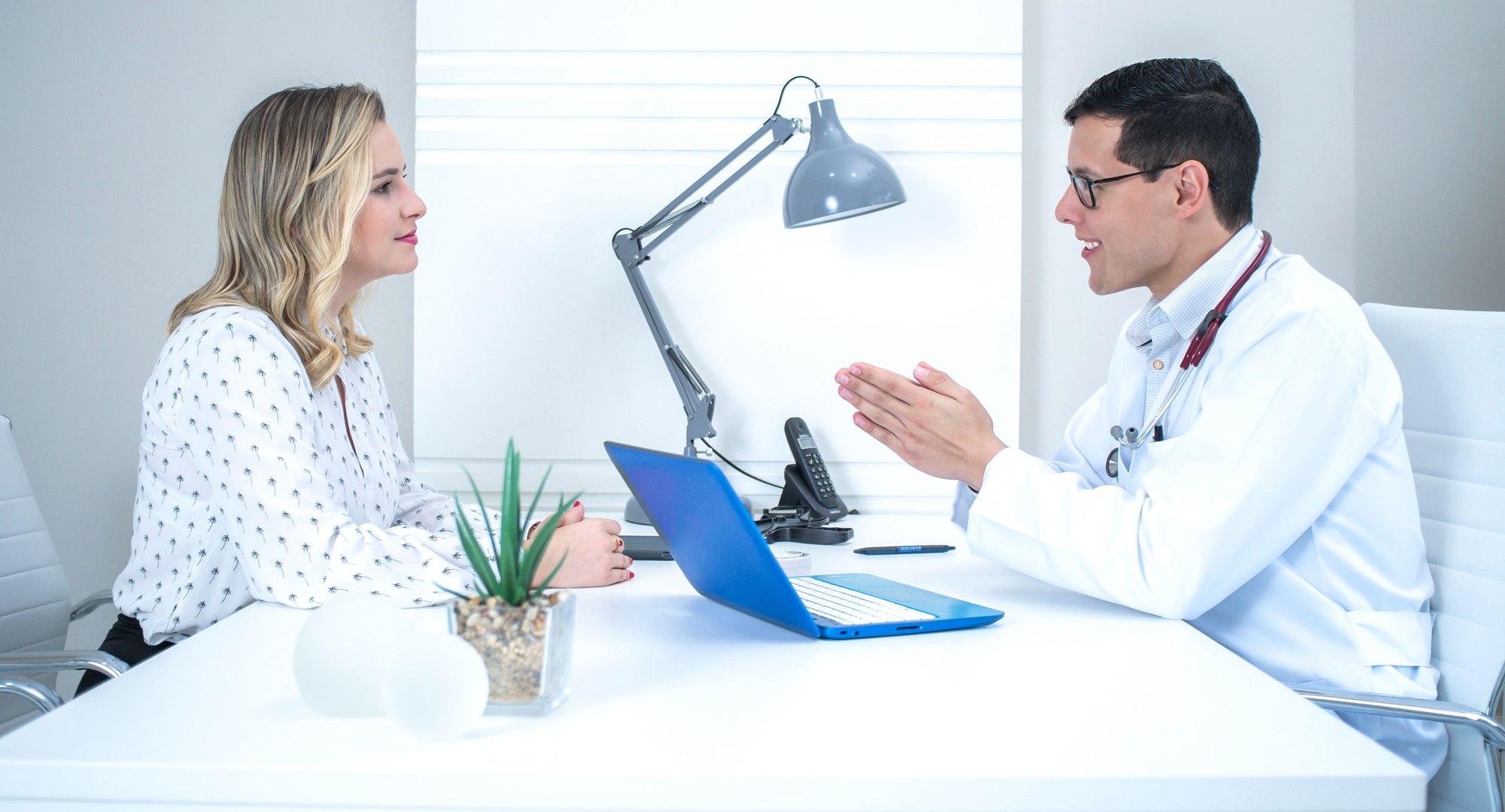 Médica en una consulta luminosa hablando con una paciente