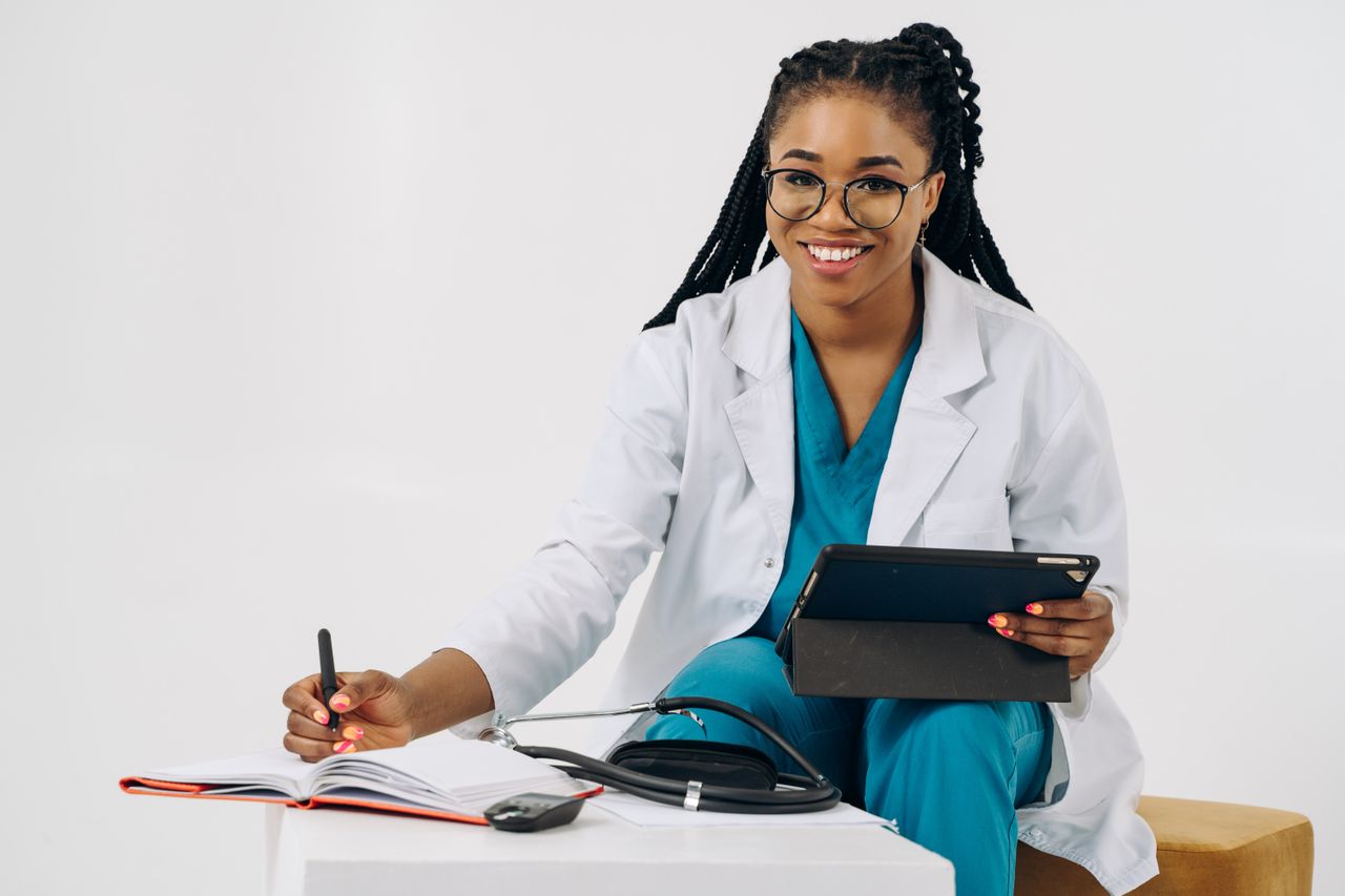 Médica tomando notas en su escritorio