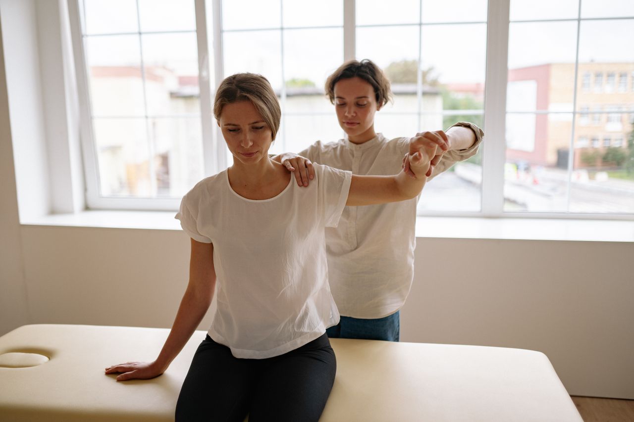 Physiotherapeutin leitet eine Armübung an