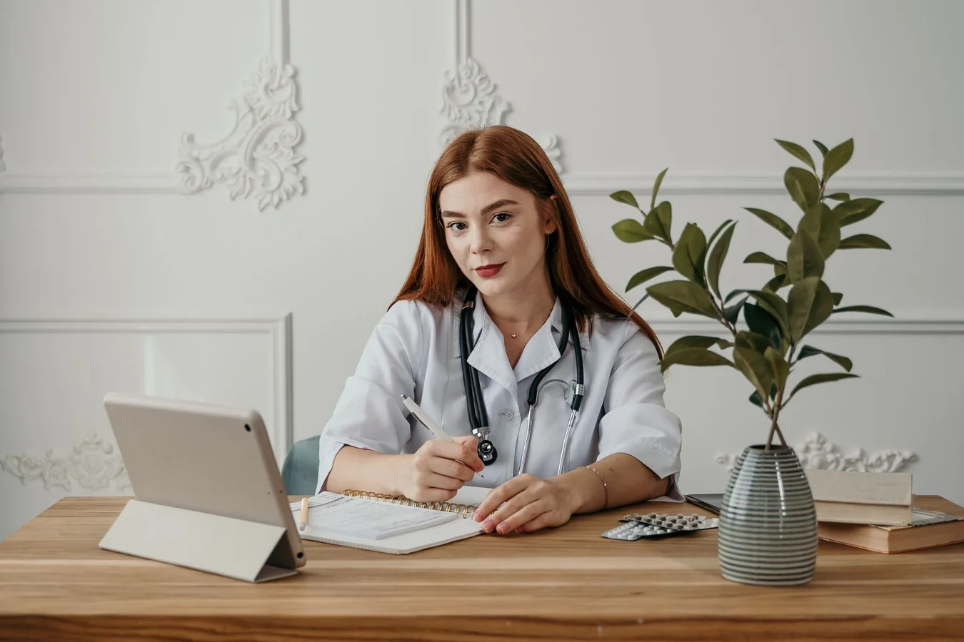 Médica trabajando con apuntes en un ordenador