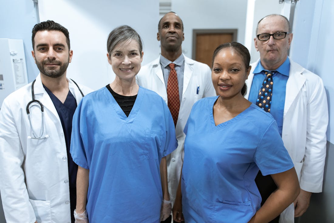 Lächelndes, diverses Team aus Ärzten und Pflegekräften im Krankenhaus